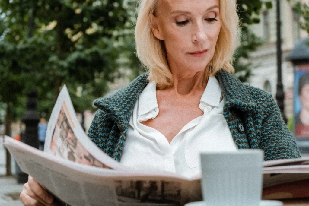 Femme ménopausée lisant un journal et profitant de la vie