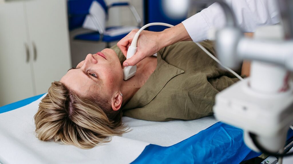 Female patient undergoing thyroid ultrasound examination